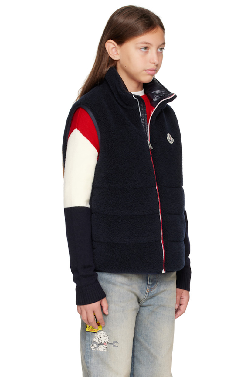 Insulated sherpa fleece vest.

· Stand collar
· Zip closure
· Felted logo patch at chest
· Seam pockets
· Full satin lining

Supplier color: Blue navy

Model measures 55" / 139.7 cm tall and wears size 12Y.

Moncler Enfant Size: child's height
8Y: 51.2" / 130 cm 
10Y: 55.2" / 140 cm 
12Y: 59.8" / 152 cm 
14Y: 64.6" / 164 cm