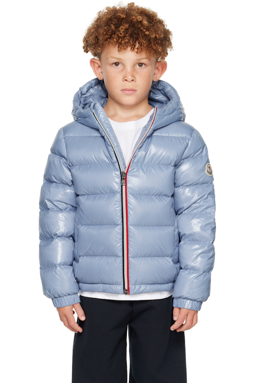 Down-filled and quilted nylon satin jacket. 

· DIST-certified down
· Hood at stand collar
· Zip closure
· Welt pockets at front
· Elasticized hem and cuffs
· Felted logo patch at sleeve
· Fully lined
· Hand-wash

Supplier color: Light blue

Model measures 48.5" / 123.2 cm tall and wears size 8Y.

Moncler Enfant Size: child's height
8Y: 51.2" / 130 cm 
10Y: 55.2" / 140 cm 
12Y: 59.8" / 152 cm 
14Y: 64.6" / 164 cm 

Fill: 90% goose down, 10% feather.