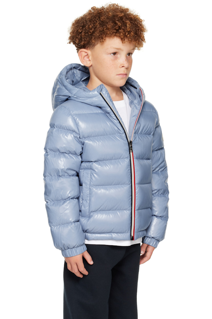 Down-filled and quilted nylon satin jacket. 

· DIST-certified down
· Hood at stand collar
· Zip closure
· Welt pockets at front
· Elasticized hem and cuffs
· Felted logo patch at sleeve
· Fully lined
· Hand-wash

Supplier color: Light blue

Model measures 48.5" / 123.2 cm tall and wears size 8Y.

Moncler Enfant Size: child's height
8Y: 51.2" / 130 cm 
10Y: 55.2" / 140 cm 
12Y: 59.8" / 152 cm 
14Y: 64.6" / 164 cm 

Fill: 90% goose down, 10% feather.