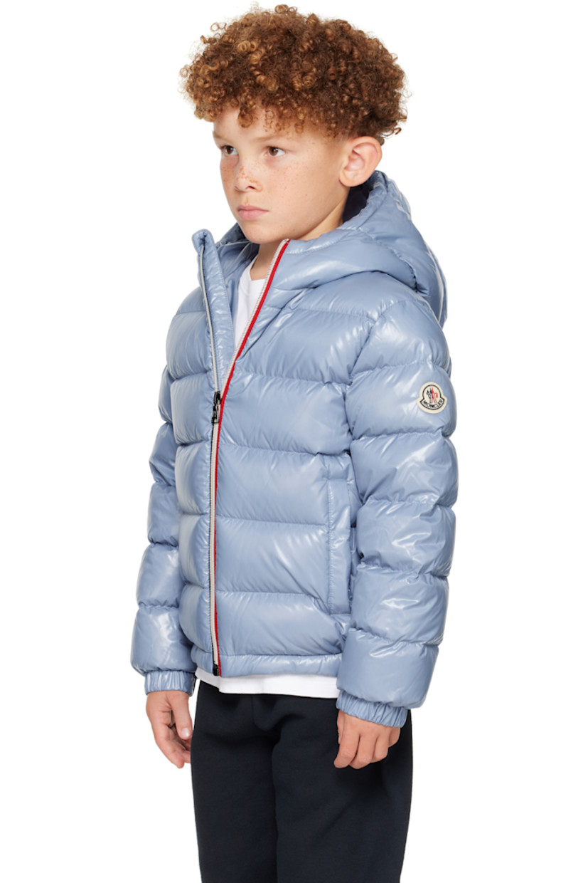 Down-filled and quilted nylon satin jacket. 

· DIST-certified down
· Hood at stand collar
· Zip closure
· Welt pockets at front
· Elasticized hem and cuffs
· Felted logo patch at sleeve
· Fully lined
· Hand-wash

Supplier color: Light blue

Model measures 48.5" / 123.2 cm tall and wears size 8Y.

Moncler Enfant Size: child's height
8Y: 51.2" / 130 cm 
10Y: 55.2" / 140 cm 
12Y: 59.8" / 152 cm 
14Y: 64.6" / 164 cm 

Fill: 90% goose down, 10% feather.