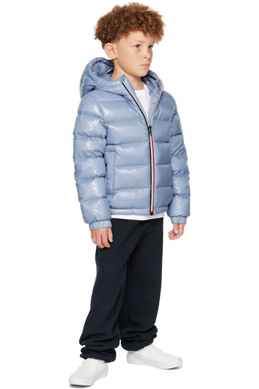 Down-filled and quilted nylon satin jacket. 

· DIST-certified down
· Hood at stand collar
· Zip closure
· Welt pockets at front
· Elasticized hem and cuffs
· Felted logo patch at sleeve
· Fully lined
· Hand-wash

Supplier color: Light blue

Model measures 48.5" / 123.2 cm tall and wears size 8Y.

Moncler Enfant Size: child's height
8Y: 51.2" / 130 cm 
10Y: 55.2" / 140 cm 
12Y: 59.8" / 152 cm 
14Y: 64.6" / 164 cm 

Fill: 90% goose down, 10% feather.