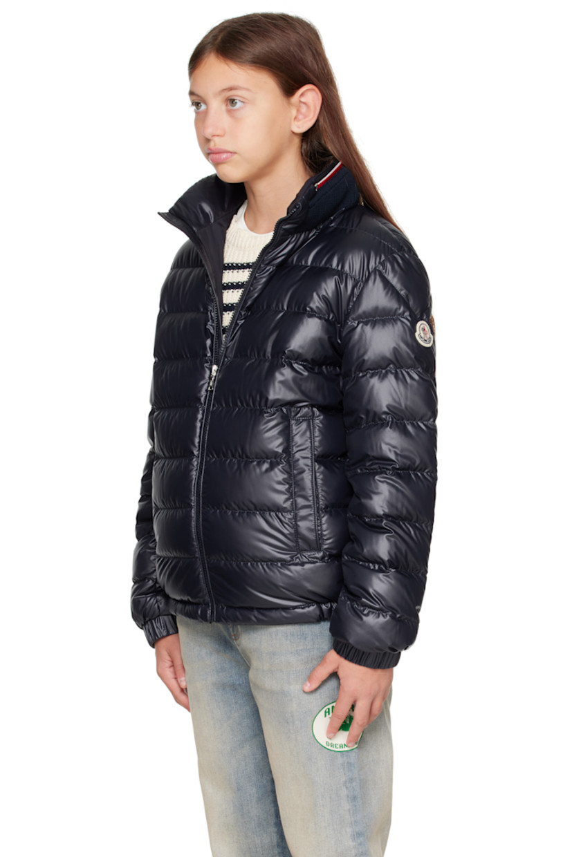 Down-filled and quilted recycled polyester satin jacket. 

· DIST-certified down
· Rib-knit stand collar
· Zip closure
· Welt pockets at front
· Partially elasticized hem
· Felted logo patch at sleeve
· Elasticized cuffs
· Fully lined

Supplier color: Blue navy

Model measures 55" / 139.7 cm tall and wears size 12Y.

Moncler Enfant Size: child's height
8Y: 51.2" / 130 cm 
10Y: 55.2" / 140 cm 
12Y: 59.8" / 152 cm 
14Y: 64.6" / 164 cm