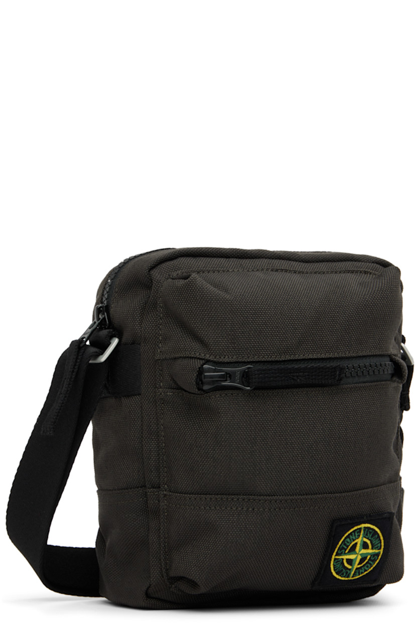 CORDURA® 1500 nylon canvas pouch.

· Water-resistant
· Adjustable crossbody strap
· Embroidered logo patch at face
· Zip compartment at face
· Logo flag at side
· Zip closure
· Zip pocket at interior
· Polyurethane-coated ripstop lining
· H7.5" x W6.5" x D2.25"

Supplier color: Lead grey