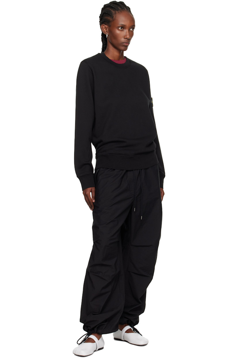 Garment-dyed organic cotton fleece sweatshirt. 

· Overlock stitching throughout
· Rib-knit crewneck, hem, and cuffs
· Detachable felted logo patch at sleeve

Supplier color: Black