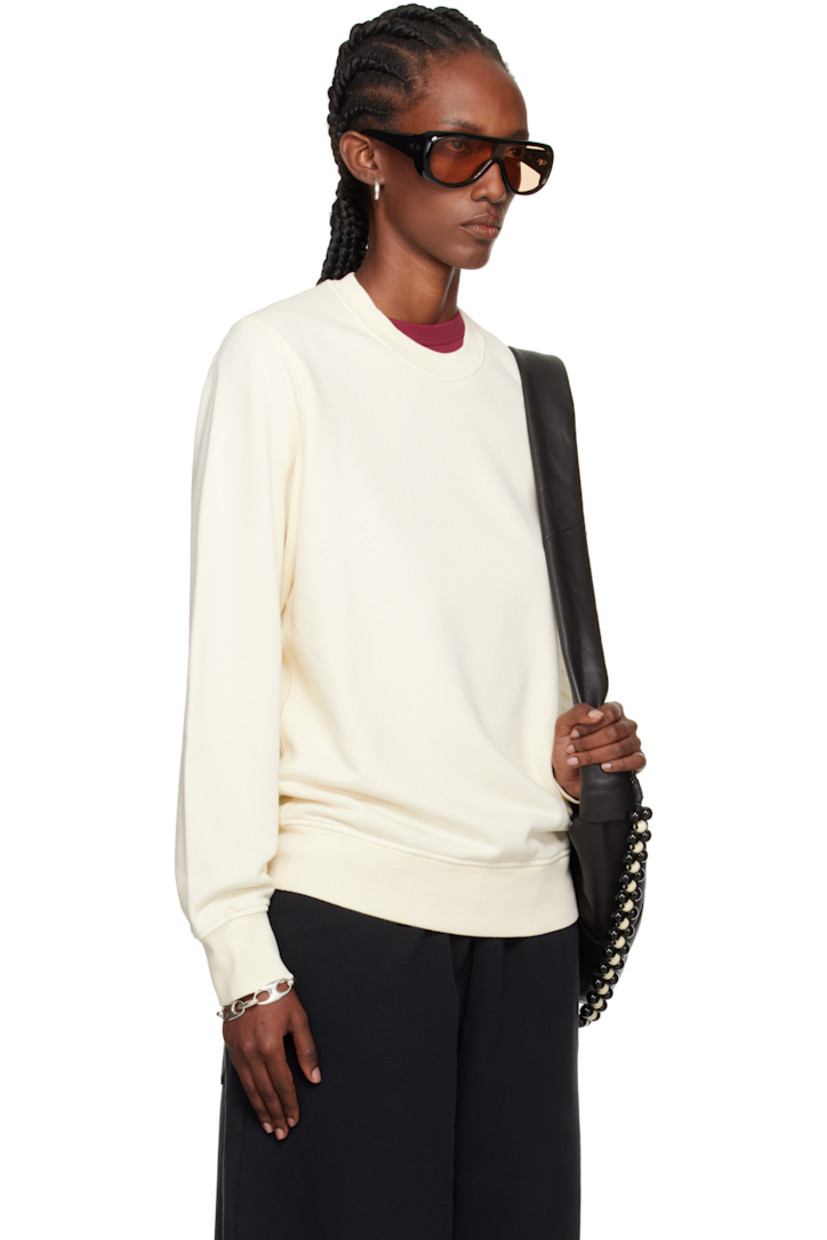 Garment-dyed organic cotton fleece sweatshirt. 

· Overlock stitching throughout
· Rib-knit crewneck, hem, and cuffs
· Detachable felted logo patch at sleeve

Supplier color: Ivory