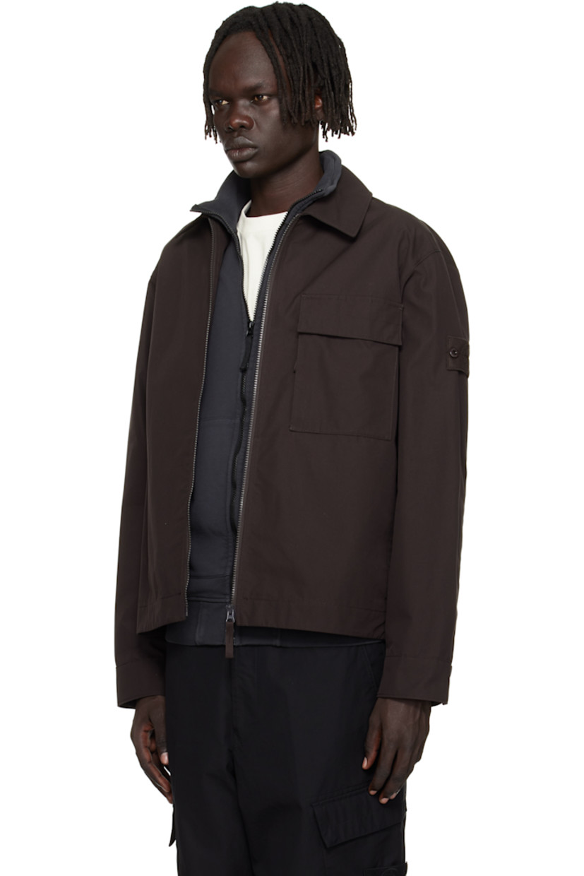 Organic cotton canvas overshirt. 

· Spread collar 
· Two-way zip closure
· Flap pocket at chest
· Seam pockets at waist
· Detachable felted logo patch at sleeve
· Press-stud barrel cuffs
· Adjustable press-stud tabs at back hem 

Part of the Ghost collection.

Supplier color: Dark brown