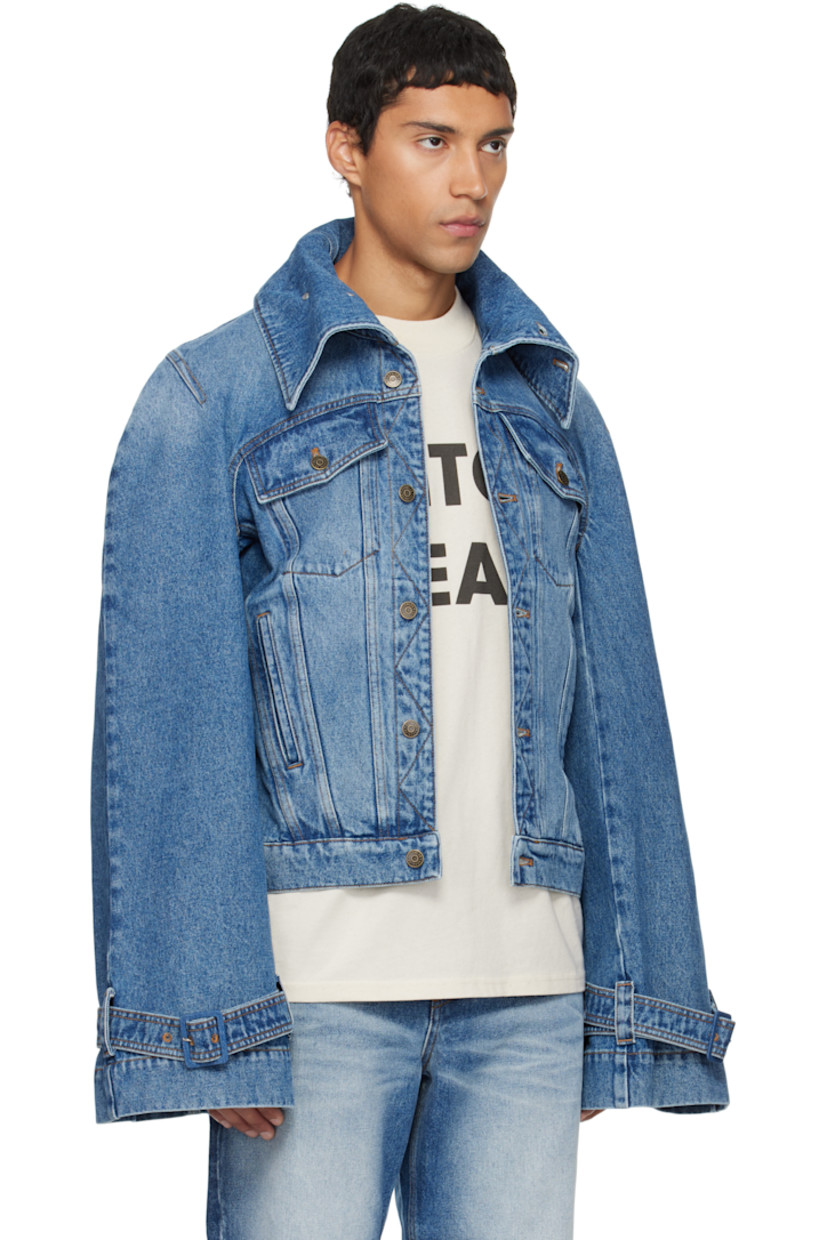 Non-stretch denim jacket.

· Fading throughout
· Button fastenings at funnel neck
· Button closure
· Flap and welt pockets at front
· Yoke sleeves
· Pin-buckle strap at cuffs
· Contrast stitching in tan

Supplier color: Blue