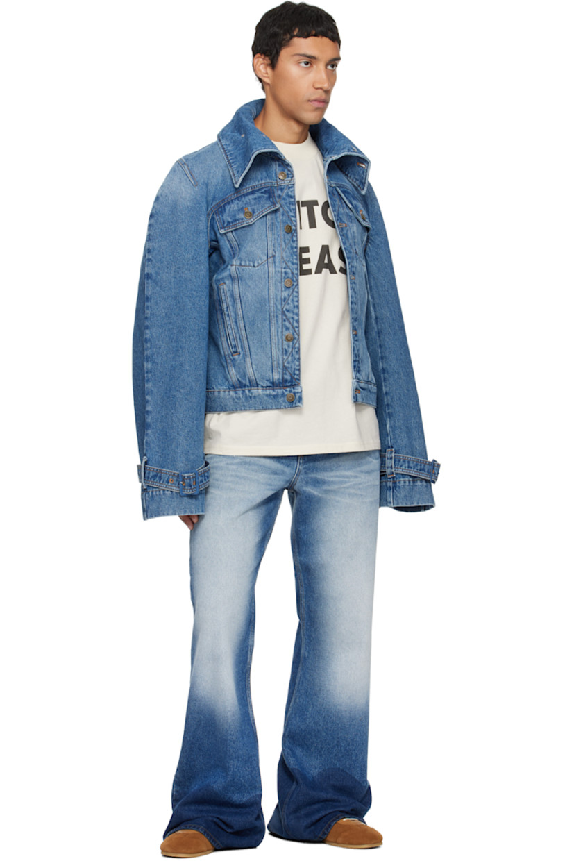Non-stretch denim jacket.

· Fading throughout
· Button fastenings at funnel neck
· Button closure
· Flap and welt pockets at front
· Yoke sleeves
· Pin-buckle strap at cuffs
· Contrast stitching in tan

Supplier color: Blue