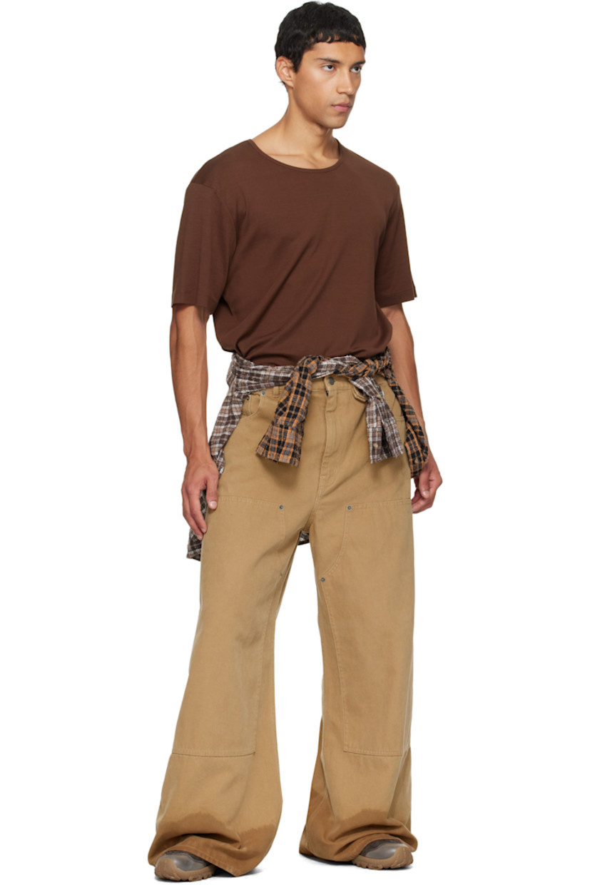 Cotton canvas jeans. 

· Wide-leg 
· Belt loops
· Press-stud tab at waistband 
· Five-pocket styling
· Zip fly 
· Rivets and reinforced panel at knees 
· Discoloration at cuffs
· Logo patch at back waistband

Supplier color: Beige