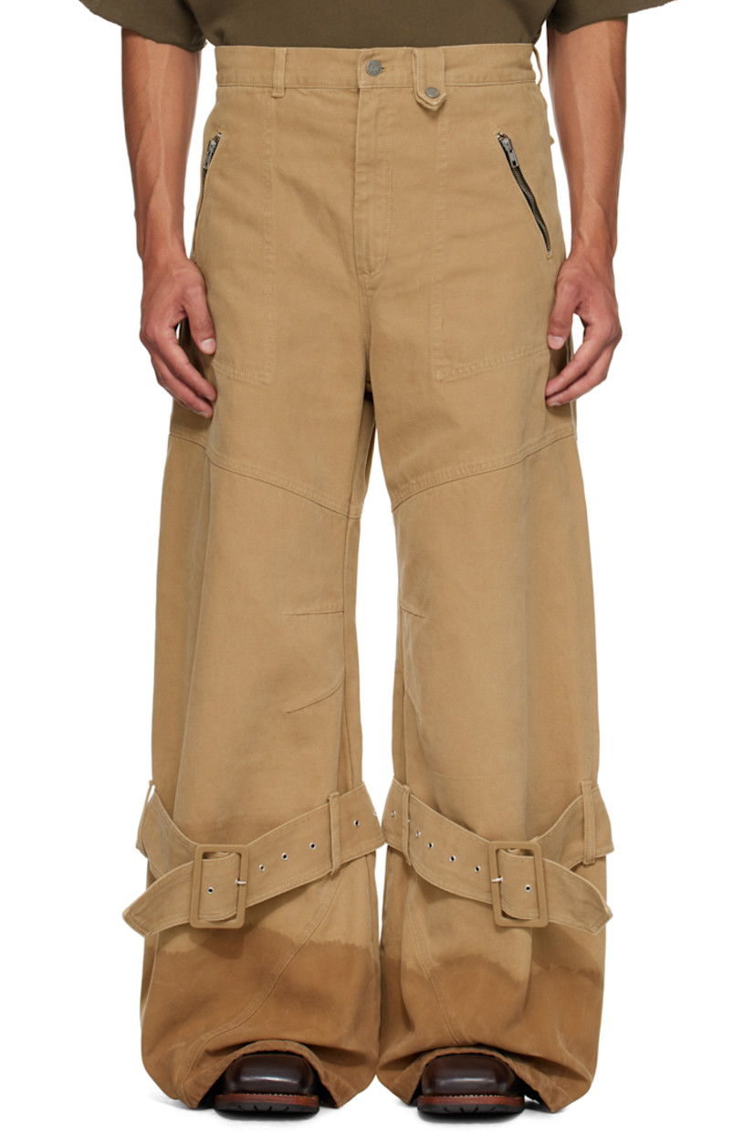 Cotton canvas jeans. 

· Belt loops
· Four-pocket styling
· Zip fly 
· Darts at knees
· Loops, pin-buckle strap, and discoloration at cuffs
· Discoloration at cuffs
· Logo patch at back waistband

Supplier color: Beige