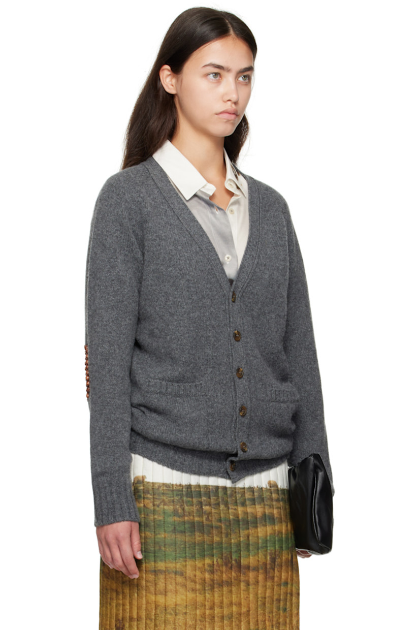 Knit wool cardigan.

· Rib-knit Y-neck, hem, and cuffs
· Button closure
· Patch pockets at front
· Wooden beading at elbows

Supplier color: Grey/Brown