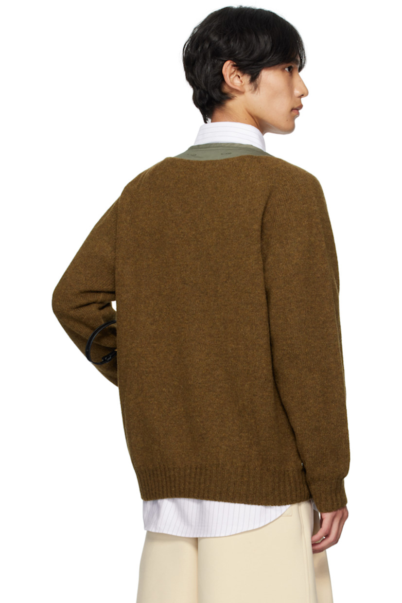 Paneled knit Shetland wool jacket.

· Alpha Industries® quilted ripstop panel at front
· V-neck
· Button closure
· Patch pockets at waist
· Logo hardware at side seam
· Button holes at back collar

Supplier color: Olive