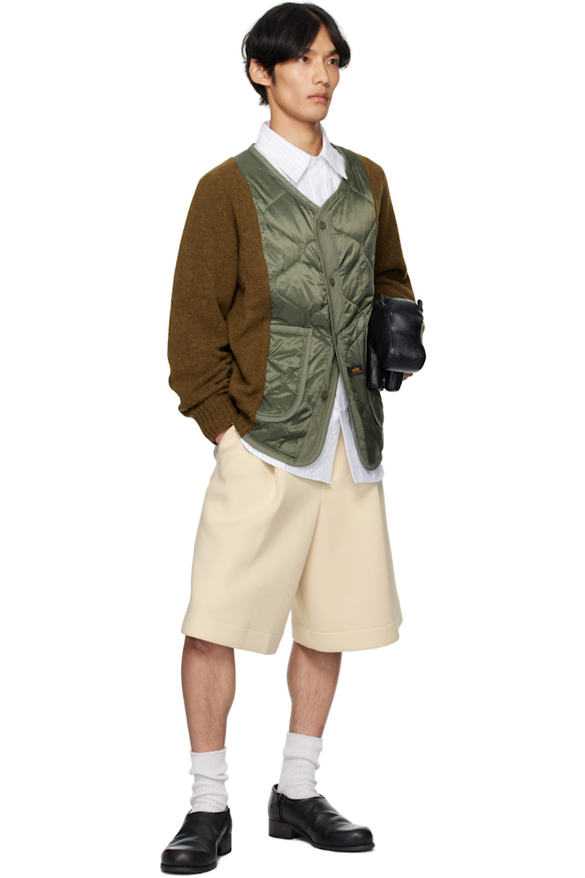 Paneled knit Shetland wool jacket.

· Alpha Industries® quilted ripstop panel at front
· V-neck
· Button closure
· Patch pockets at waist
· Logo hardware at side seam
· Button holes at back collar

Supplier color: Olive