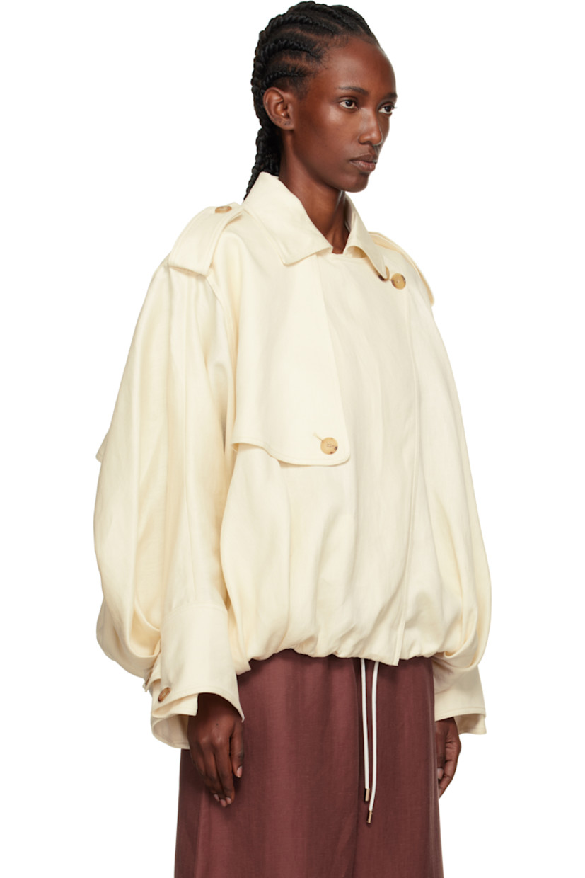Linen textured hopsack jacket. 

· Oversized
· Spread collar
· Draped button panel at zip closure
· Buttoned storm flap at chest and back yoke 
· Welt pockets at waist
· Gathering and cord-lock drawstring at hem 
· Epaulets
· Button tab at buttoned barrel cuffs

Supplier color: Ivory