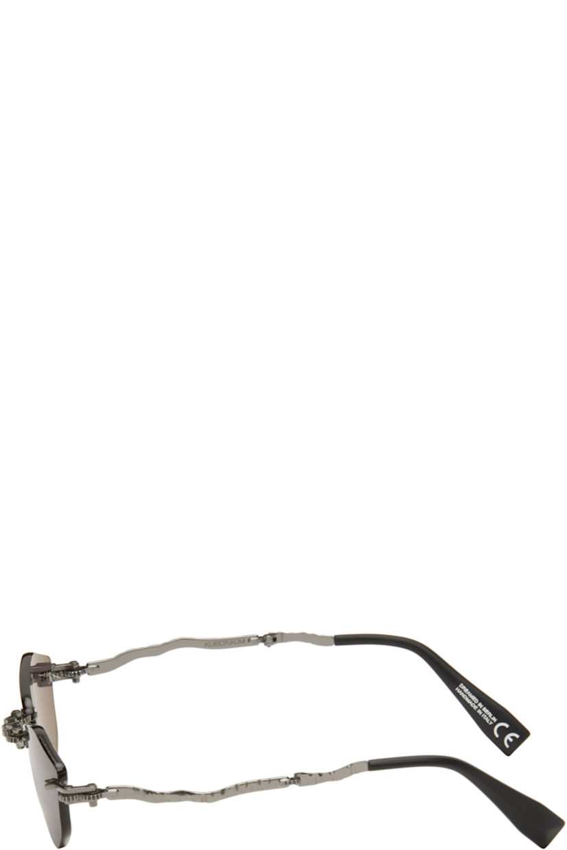 Handcrafted collapsible hexagonal metal-frame sunglasses.

· Spur gears at hinges
· Engraved detailing throughout
· Gray lenses
· Adjustable metal nose pads
· Sculptural arms
· Acetate temple tips
· Includes case
· Size: 51.19 140

Supplier color: Gunmetal