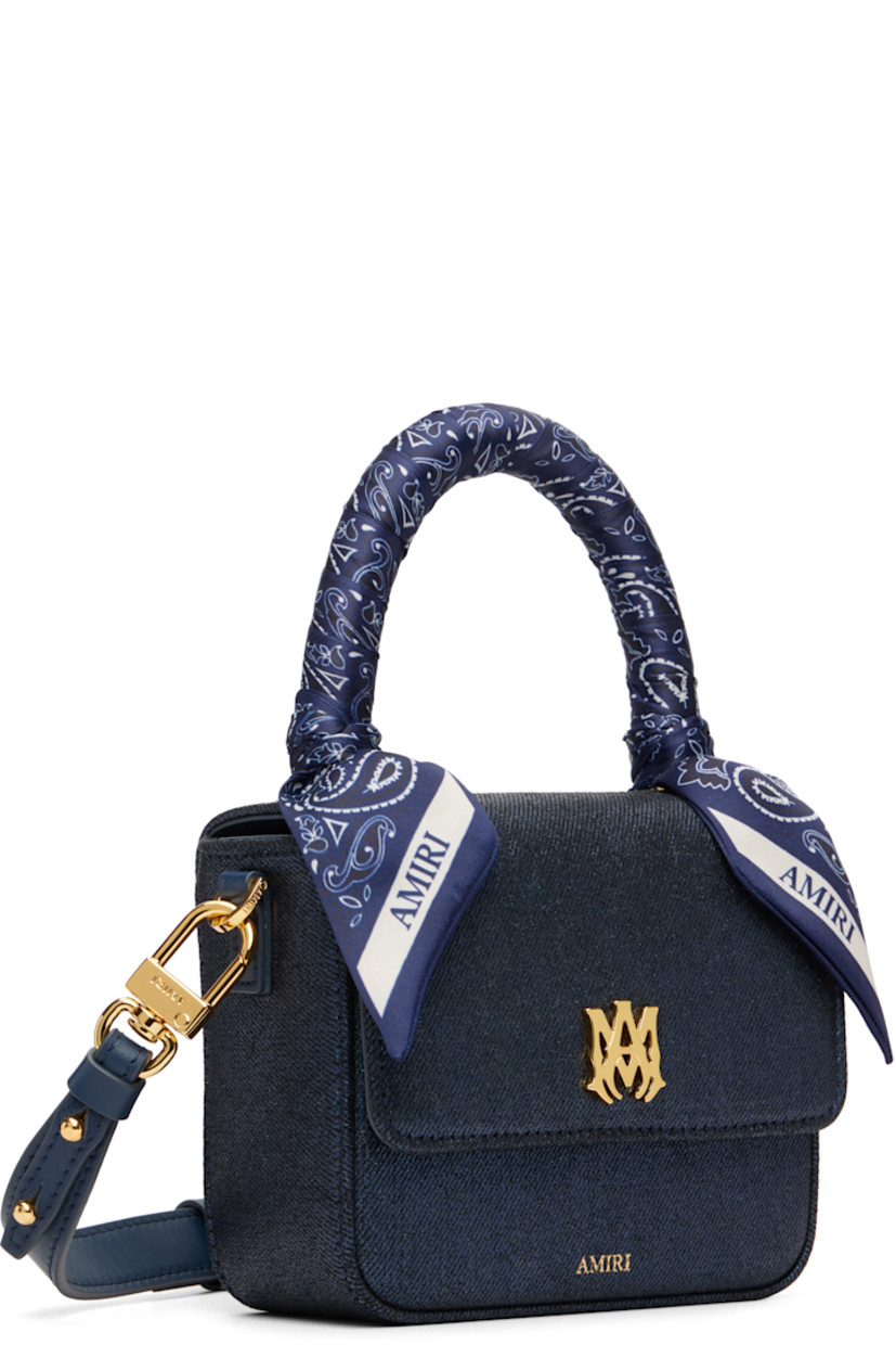 Non-stretch waxed denim top handle bag.

· Bandana-style satin trim at carry handle
· Leather adjustable and detachable crossbody strap
· Logo hardware and concealed patch pocket at face
· Logo stamp at face and back
· Magnetic flap closure
· Zip pocket at interior 
· Gold-tone hardware
· H5" x W6" x D2.5"
· Total height: H9"

Supplier color: Wet shimmer
