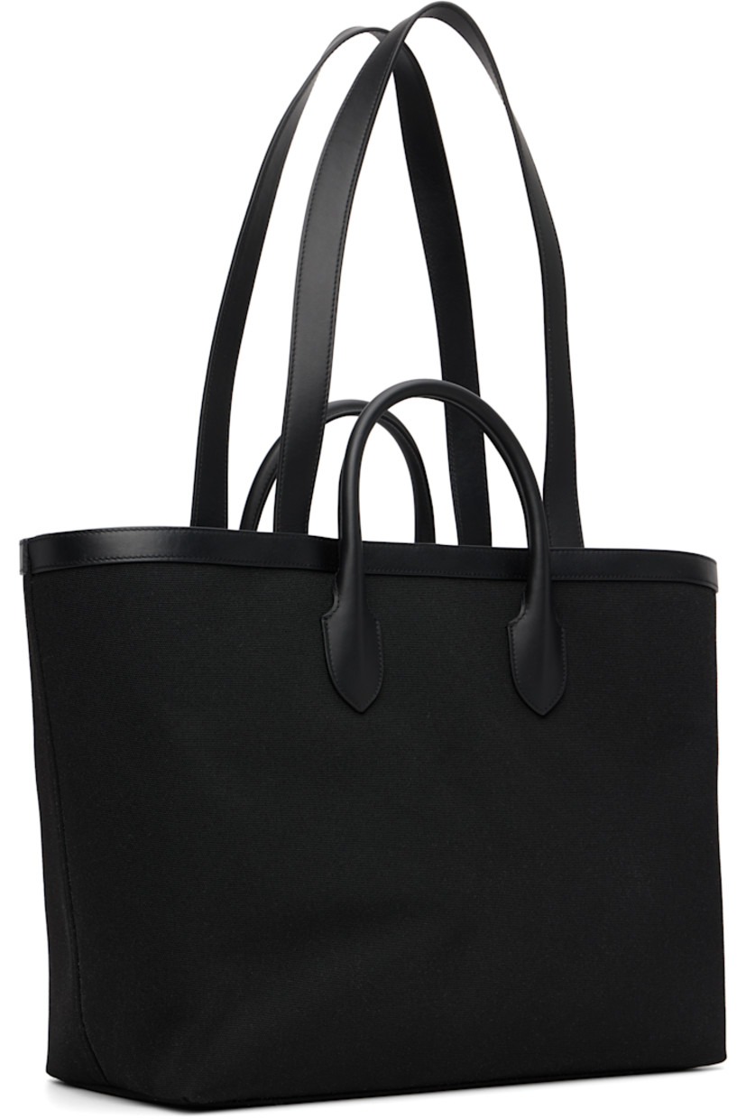 Canvas tote. 

· Buffed leather trim throughout 
· Rolled carry handles
· Fixed shoulder straps 
· Logo stamp at face 
· Embroidered text and logo at face
· Logo-engraved lanyard-clasp closure 
· Zip pocket at interior 
· Full logo-woven satin lining 
· H13" x W21" x D7"

Supplier color: Black