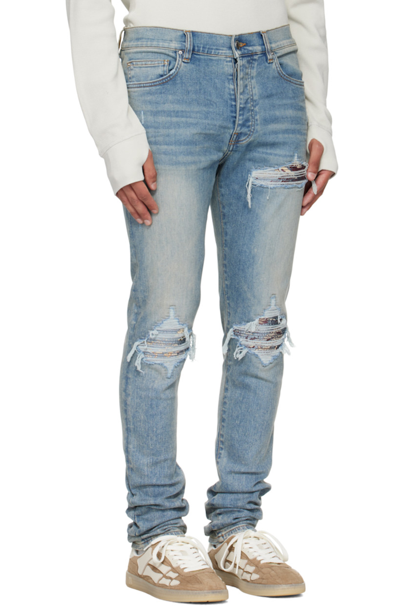 Stretch denim jeans.

· Fading, whiskering, and distressing throughout
· Belt loops
· Five-pocket styling
· Button fly
· Rips with quilted jacquard underlays at front
· Logo patch at back waistband
· Jacquard graphic at back pocket
· Logo plaque at back pocket
· Contrast stitching in tan

Supplier color: Medium indigo

Trim: 55% polyester, 27% acetate, 12% cotton, 6% feather.