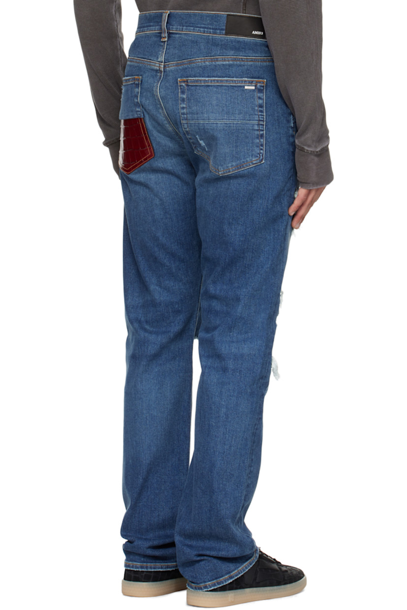Stretch denim jeans. 

· Fading, distressing, and whiskering throughout 
· Belt loops
· Five-pocket styling
· Button fly 
· Croc-embossed leather panel at legs and back
· Leather logo patch at back waistband
· Logo plaque at back pocket 
· Contrast stitching in tan 

Supplier color: Dark indigo