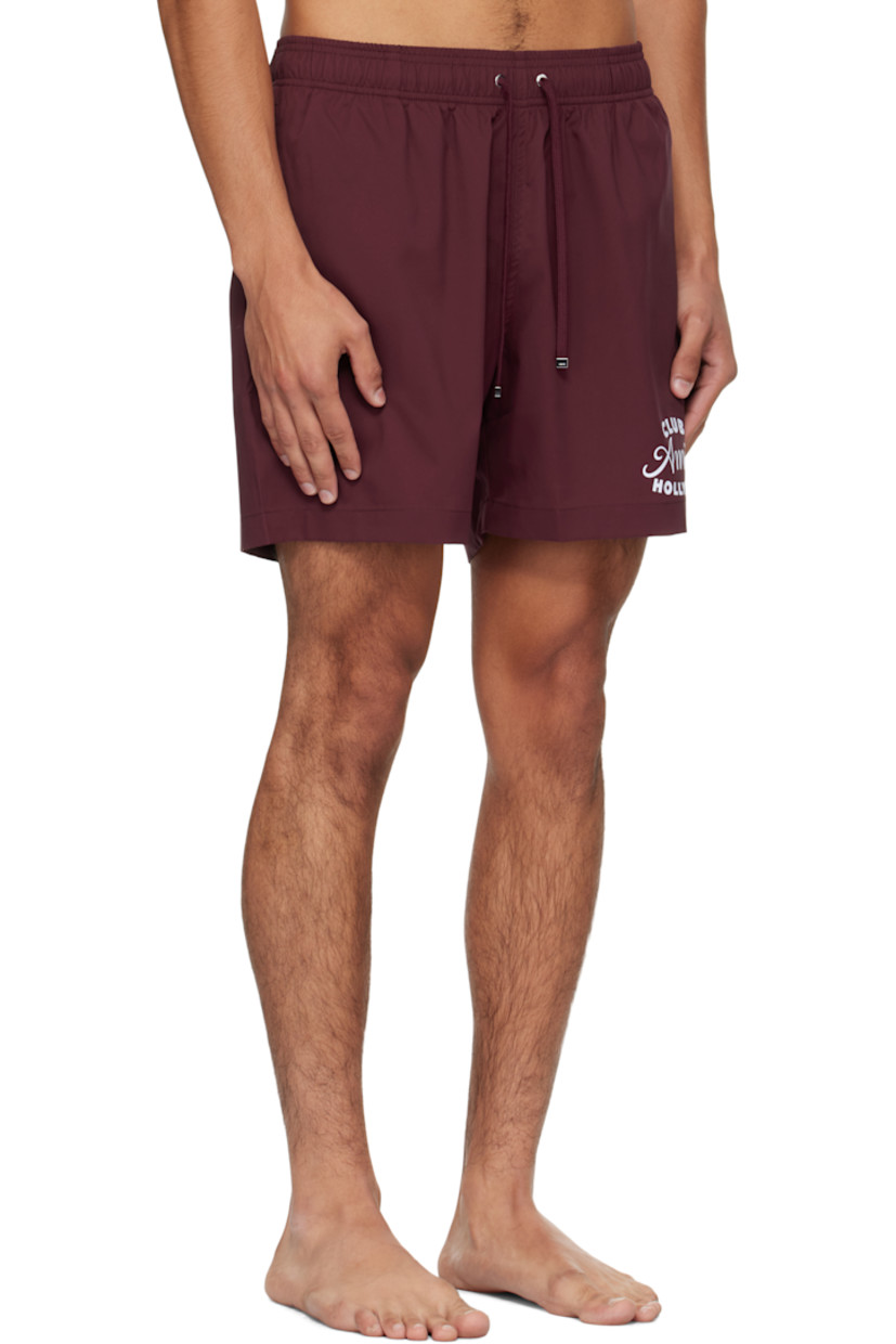Taffeta swim shorts. 

· Drawstring at elasticized waistband
· Three-pocket styling
· Logo and text printed at front 
· Rubber logo patch at back waistband
· Grommet at back pocket 
· Full mesh brief-style lining

Supplier color: Wine