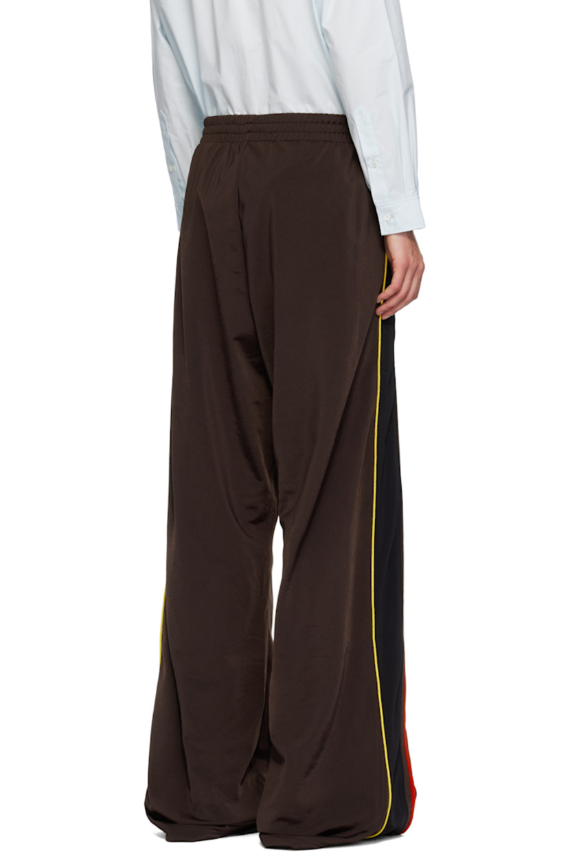 Fleece track pants.

· Concealed drawstring at elasticized waistband
· Two-pocket styling
· Logo embroidered at front
· Stripe appliqués and piping at outseams

Supplier color: Brown/Black