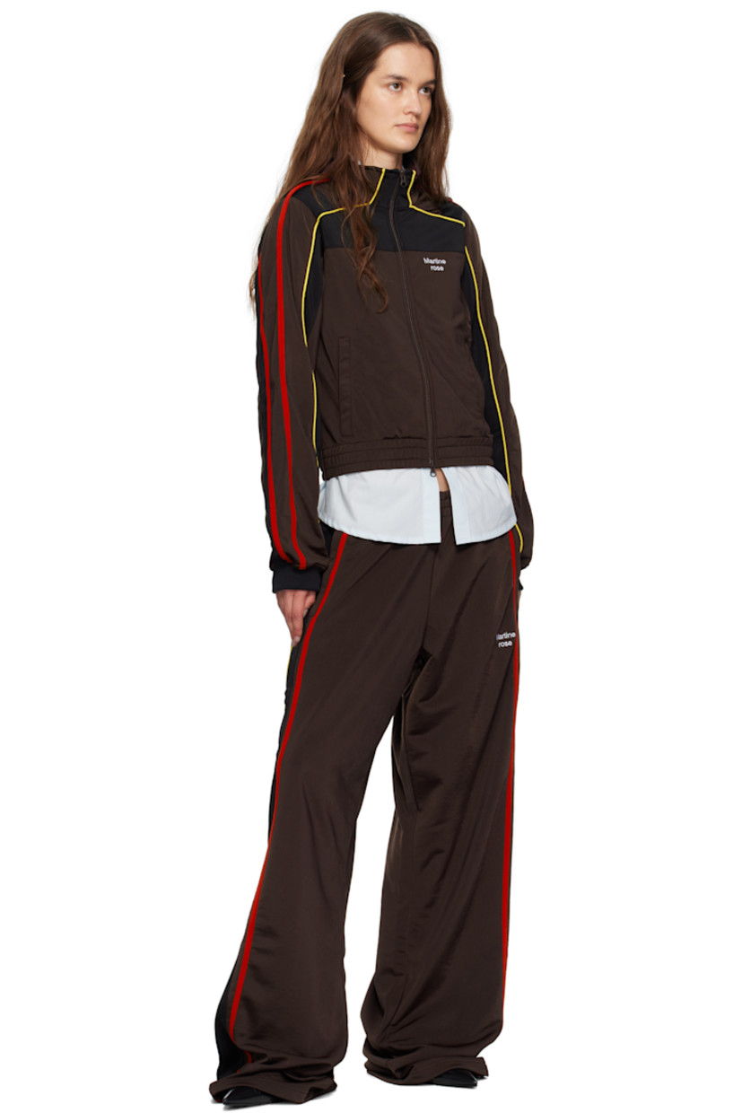 Fleece track pants.

· Concealed drawstring at elasticized waistband
· Two-pocket styling
· Logo embroidered at front
· Stripe appliqués and piping at outseams

Supplier color: Brown/Black