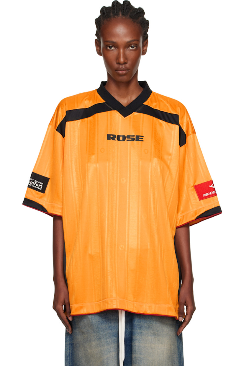 Jersey T-shirt.

· Jacquard graphic pattern throughout
· Rib-knit V-neck
· Logo printed at chest and back
· Piping at hem and cuffs
· Logo patch at cuff
· Text flocked at back

Supplier color: Yellow gold