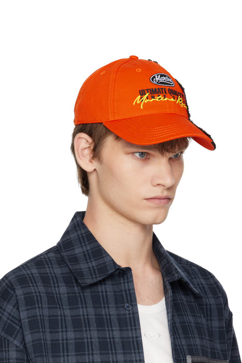 Cotton twill cap.

· Frayed edges throughout
· Embroidered eyelets at crown
· Logo patch at face and side
· Logo embroidered at face and back face
· Text printed at curved brim and side
· Velcro fastening
· Poplin lining

Supplier color: Orange