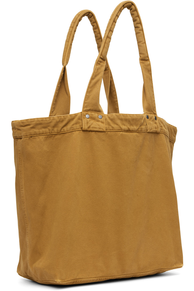 Canvas tote.

· Padded shoulder straps
· Logo-engraved O-ring and printed logo at face
· Clasp fastening at throat
· Zip pocket at interior
· H13.5" x W20" x D7"

Supplier color: Brown turmeric