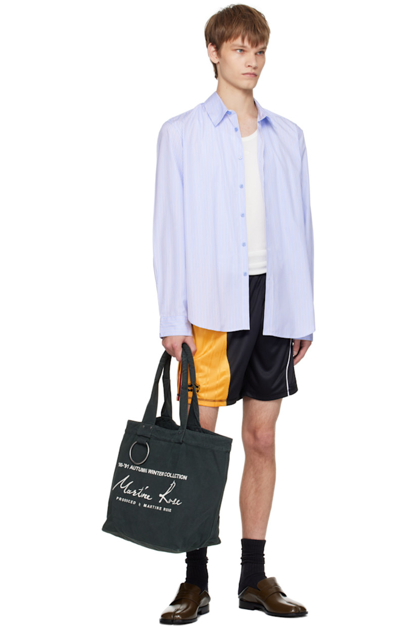 Cotton poplin shirt.

· Stripes throughout
· Spread collar
· Button closure
· Logo patch at front
· Shirttail hem
· Buttoned barrel cuffs
· Box pleat at back yoke

Supplier color: Blue stripe