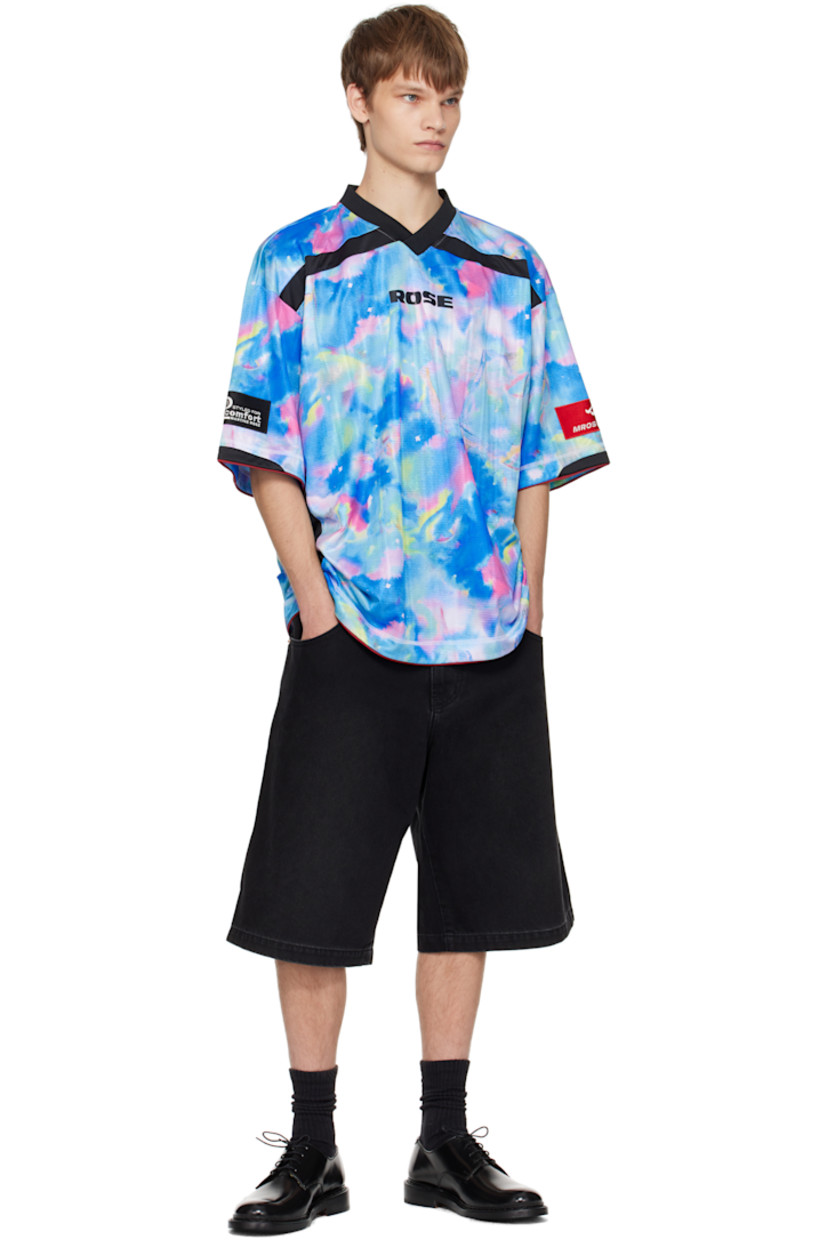 Jersey T-shirt.

· Graphic pattern printed throughout
· Rib-knit V-neck
· Logo printed at chest and back
· Piping at hem and cuffs
· Logo patch at cuff
· Text flocked at back

Supplier color: Blue watercolour