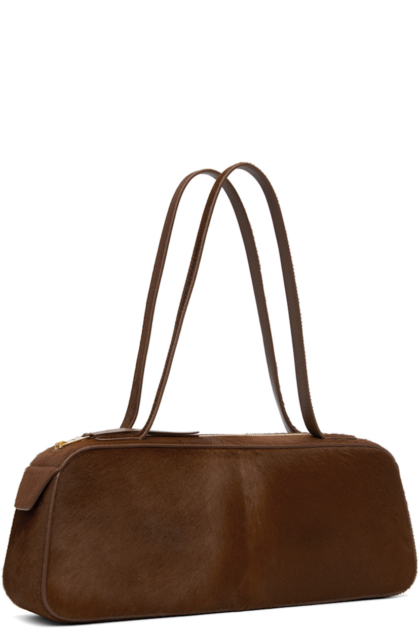 Calf-hair shoulder bag.

· Twin shoulder straps
· Zip closure
· Grained leather interior
· Unlined
· H5.5" x W14" x D3"

Supplier color: Rust haircalf