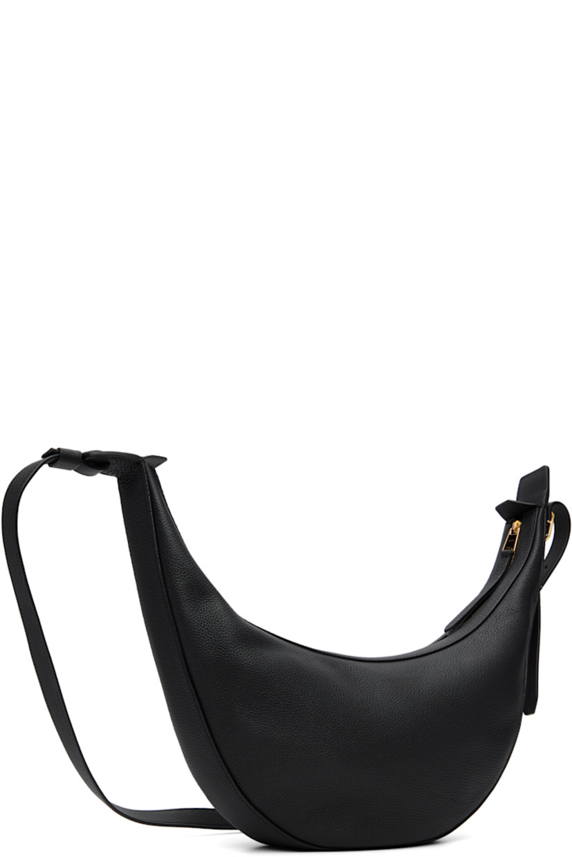 Pebble-grained calfskin shoulder bag.

· Adjustable crossbody strap
· Logo stamp at face
· Zip closure
· Suede interior
· Unlined
· H7" x W15" x D2.75"

Supplier color: Black pebbled leather