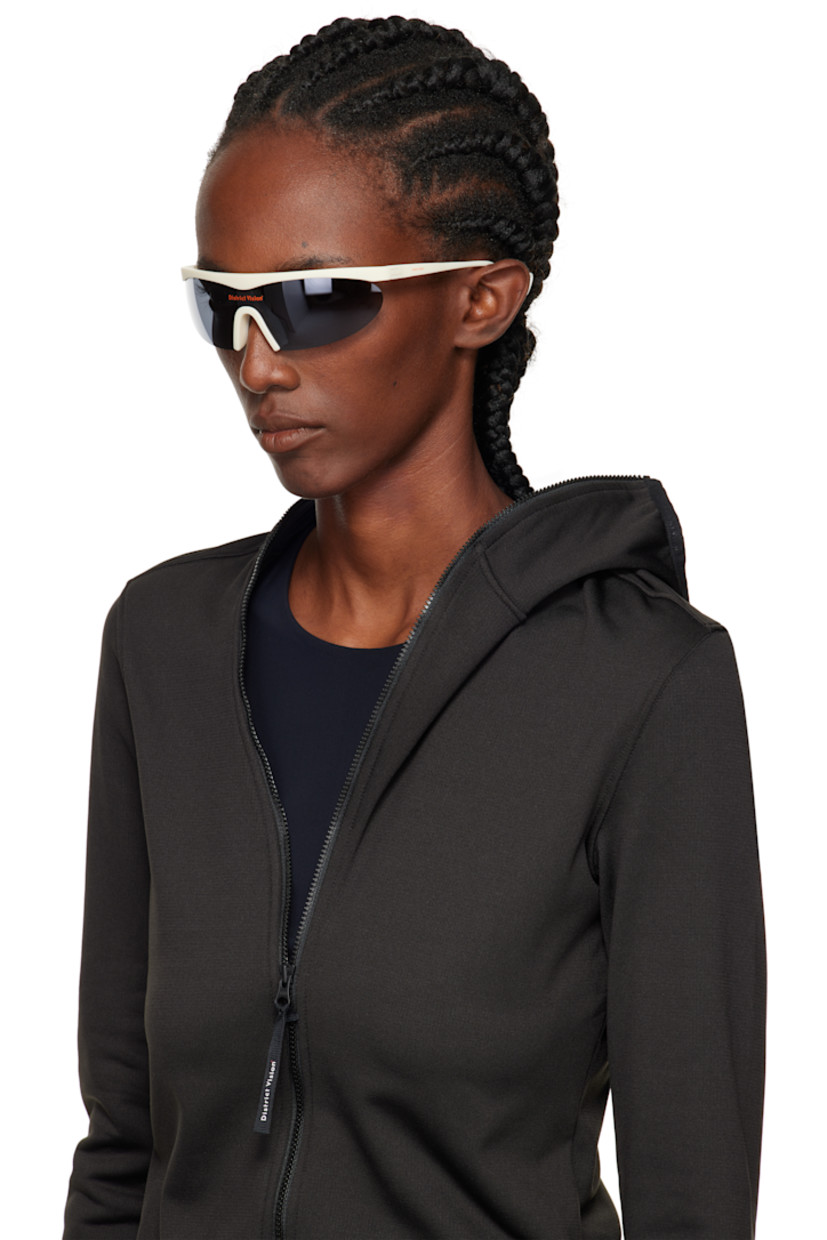 Shield-style semi-rimless acrylic-frame sunglasses.

· Mirrored gray lens with D+ lens technology
· 100% UVA/UVB protection
· Integrated rubber nose pads
· Logo printed at lens and temple
· Eyewear chain-compatible rubber temple tips
· Titanium hardware
· Includes microfiber pouch
· Size: 136 125

Supplier color: Limestone/D+ onyx mirror