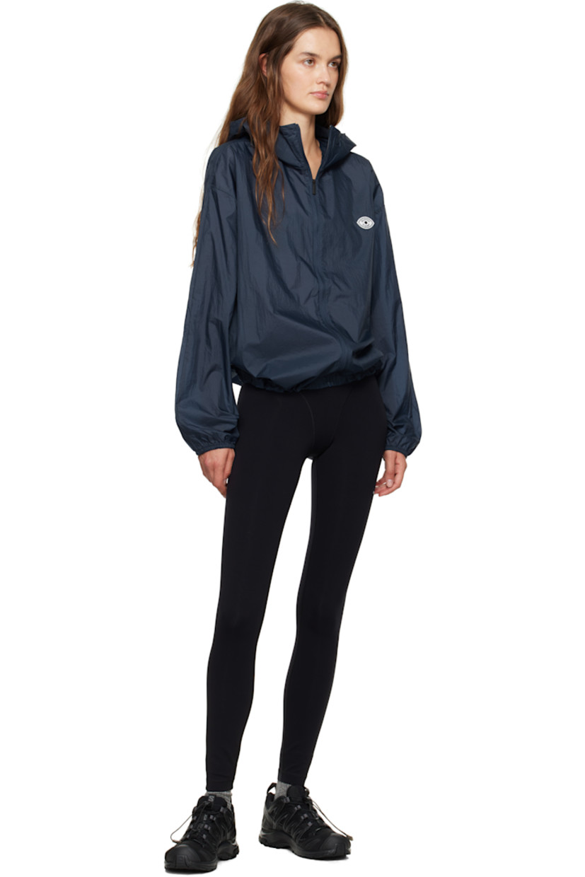 Lightweight 55 gsm nylon taffeta jacket.

· Water-repellent non-PFC DWR-coating
· Hood at stand collar
· Zip closure
· Felted logo patch at chest
· Bungee-style drawstring at hem
· Elasticized cuffs
· Storm flap at back

Supplier color: Midnight