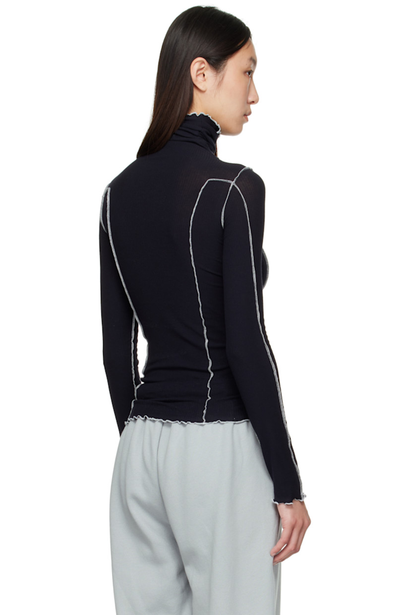 Ribbed stretch organic cotton jersey turtleneck. 

· GOTS-, OEKO-TEX®-, and OCS 100-certified
· Exposed seams throughout
· Lettuce edge at collar, hem, and cuffs
· Contrast stitching in white 

Supplier color: Murano navy/Undyed