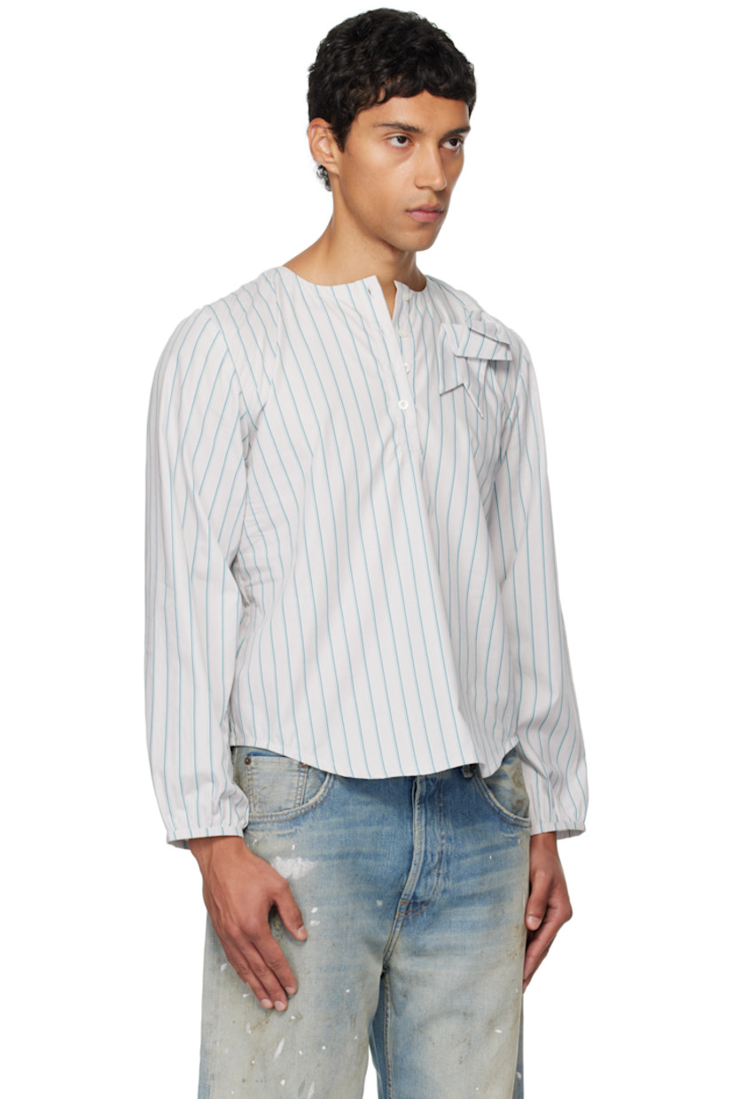 Cotton poplin henley.

· Stripes throughout 
· Round neck
· Bow appliqué at chest
· Four-button placket 
· Shirttail hem 
· Elasticized cuffs

Supplier color: Stripe
