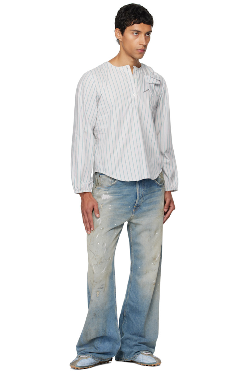 Cotton poplin henley.

· Stripes throughout 
· Round neck
· Bow appliqué at chest
· Four-button placket 
· Shirttail hem 
· Elasticized cuffs

Supplier color: Stripe