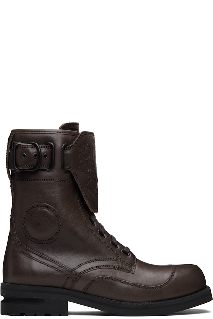 Mid-calf grained leather boots.

· Lace-up closure
· Logo graphic embroidered at vamp
· Logo embossed at tongue
· Pin-buckle strap at outer side
· Serrated edge at welt
· Treaded Vibram® rubber sole

Supplier color: Dark brown
