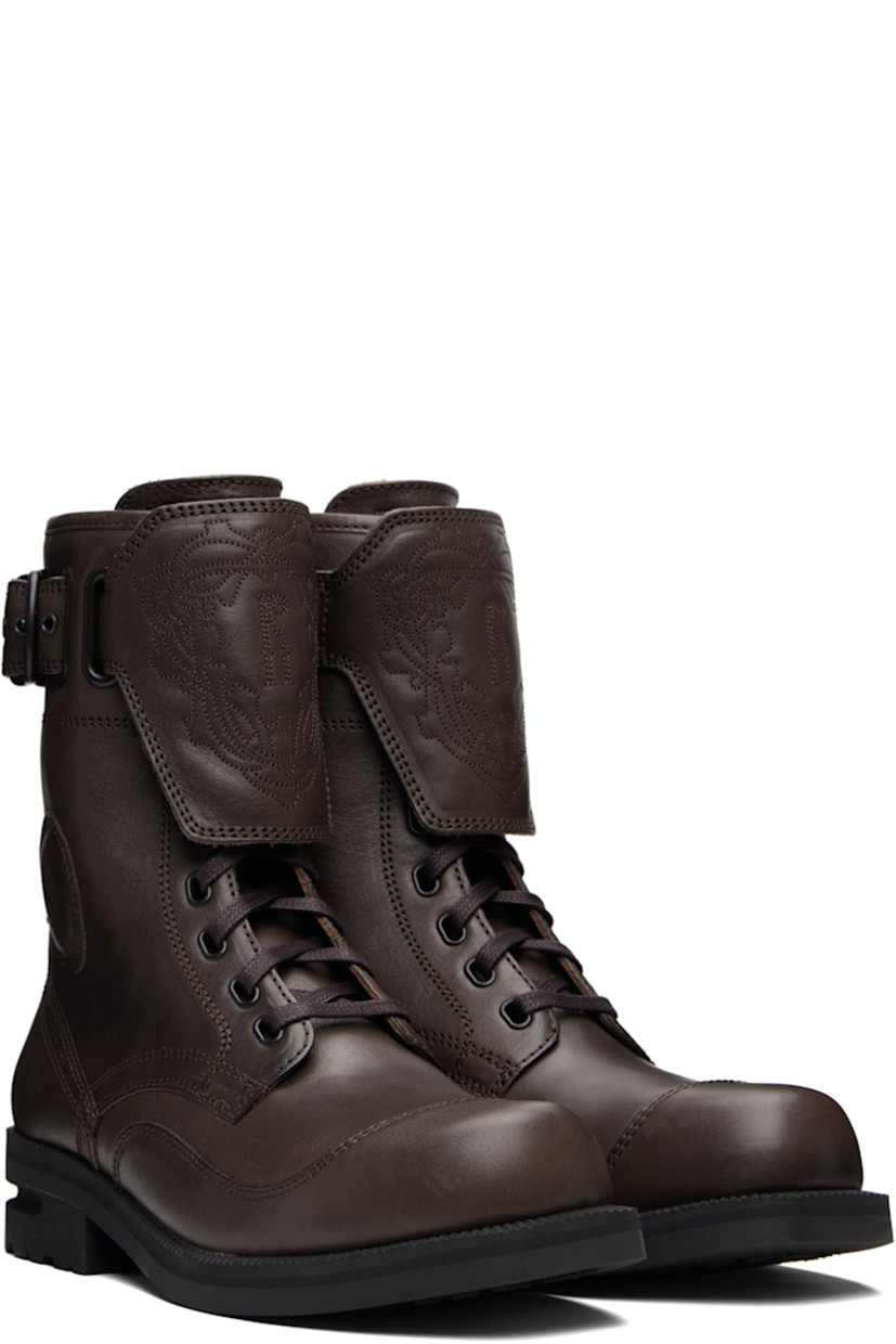 Mid-calf grained leather boots.

· Lace-up closure
· Logo graphic embroidered at vamp
· Logo embossed at tongue
· Pin-buckle strap at outer side
· Serrated edge at welt
· Treaded Vibram® rubber sole

Supplier color: Dark brown