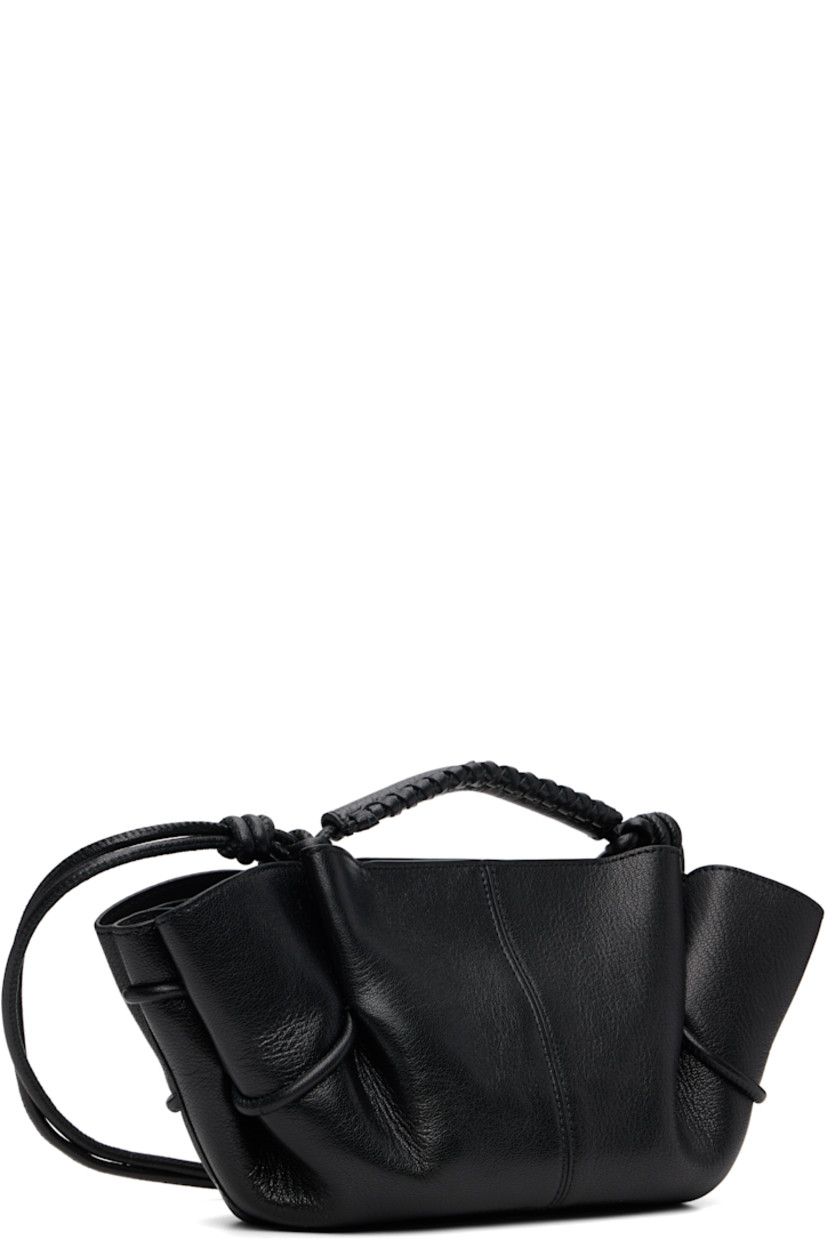 Grained lambskin top handle bag. 

· Whipstitching at rolled carry handle
· Knotted adjustable crossbody strap
· Pleats at sides
· Magnetic closure
· Goatskin lining
· H5.5" x W12" x D4"

Supplier color: Black