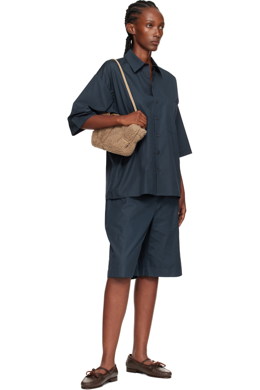 Shearling top handle bag. 

· Whipstitching at rolled carry handle
· Knotted adjustable crossbody strap
· Magnetic closure
· Lambskin lining
· H5.5" x W12" x D4"

Supplier color: Sand