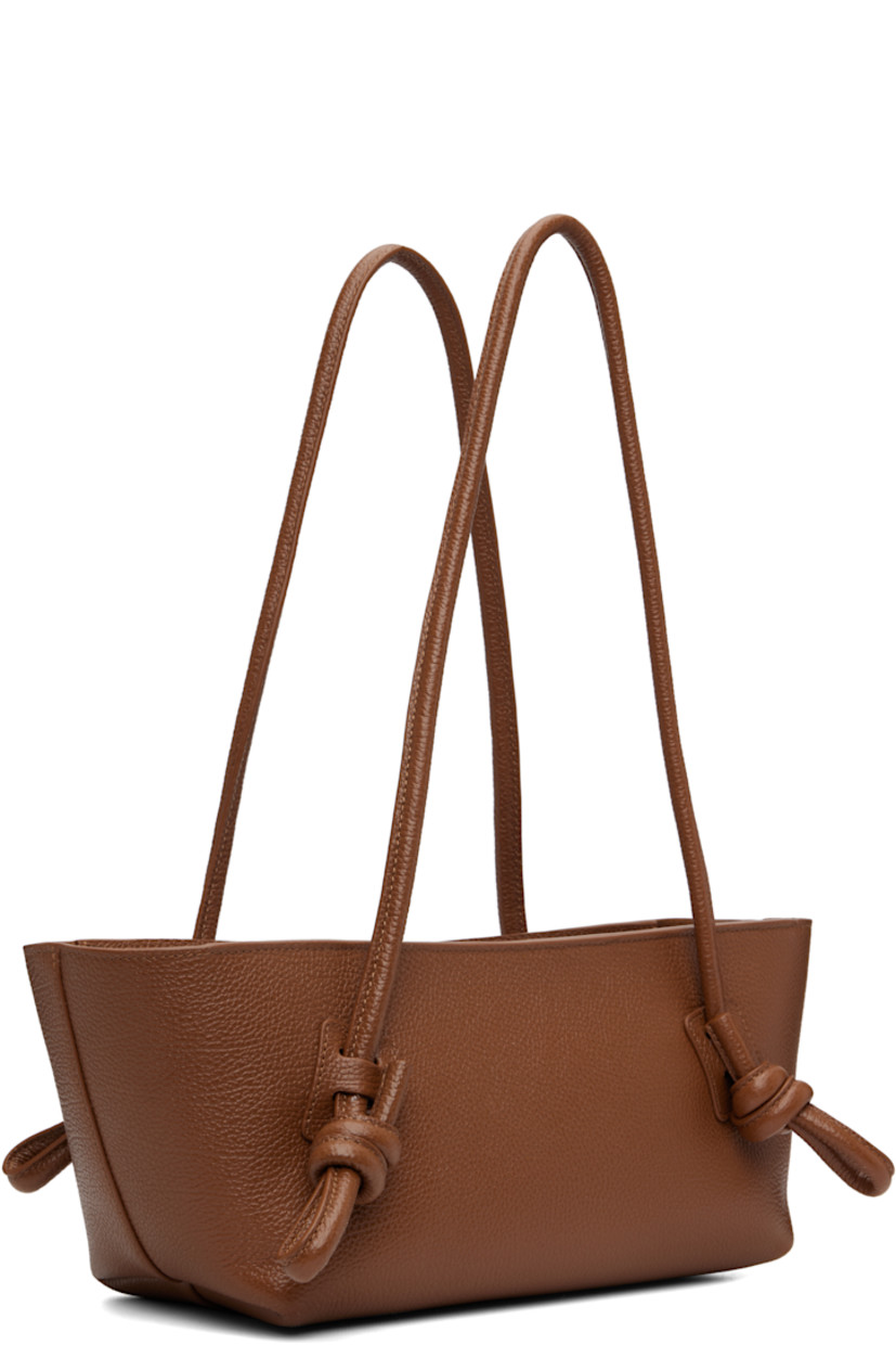 Handcrafted pebble-grained calfskin shoulder bag.

· Knotted detailing at fixed shoulder straps
· Zip closure
· Card slot at interior 
· Unlined
· Antiqued silver-tone hardware
· H5.5" x W16" x D5"

Supplier color: Tan
