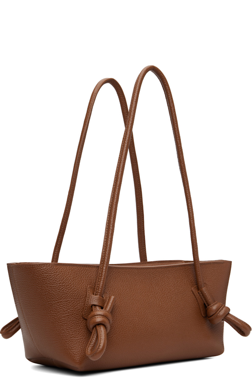 Handcrafted pebble-grained calfskin shoulder bag.

· Knotted detailing at fixed shoulder straps
· Zip closure
· Card slot at interior 
· Unlined
· Antiqued silver-tone hardware
· H5.5" x W16" x D5"

Supplier color: Tan