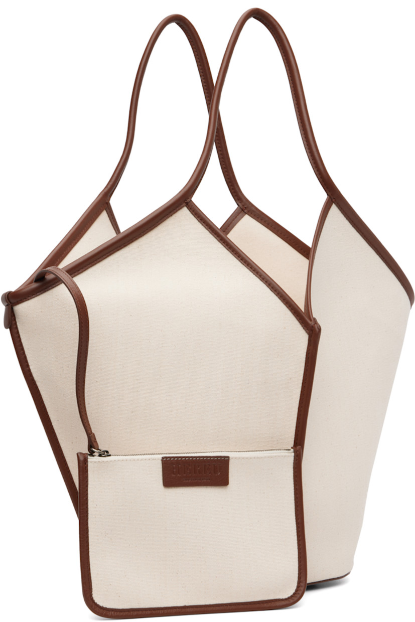 Organic cotton canvas and buffed calfskin tote. 

· Fixed shoulder straps 
· Pinched central seam at front and back
· Bumper pads at base 
· Self-tie straps at throat
· Detachable logo-embossed zip pouch at interior 
· Unlined
· Silver-tone hardware 
· H13.5" x W19" x D5"

Supplier color: Beige/Chestnut