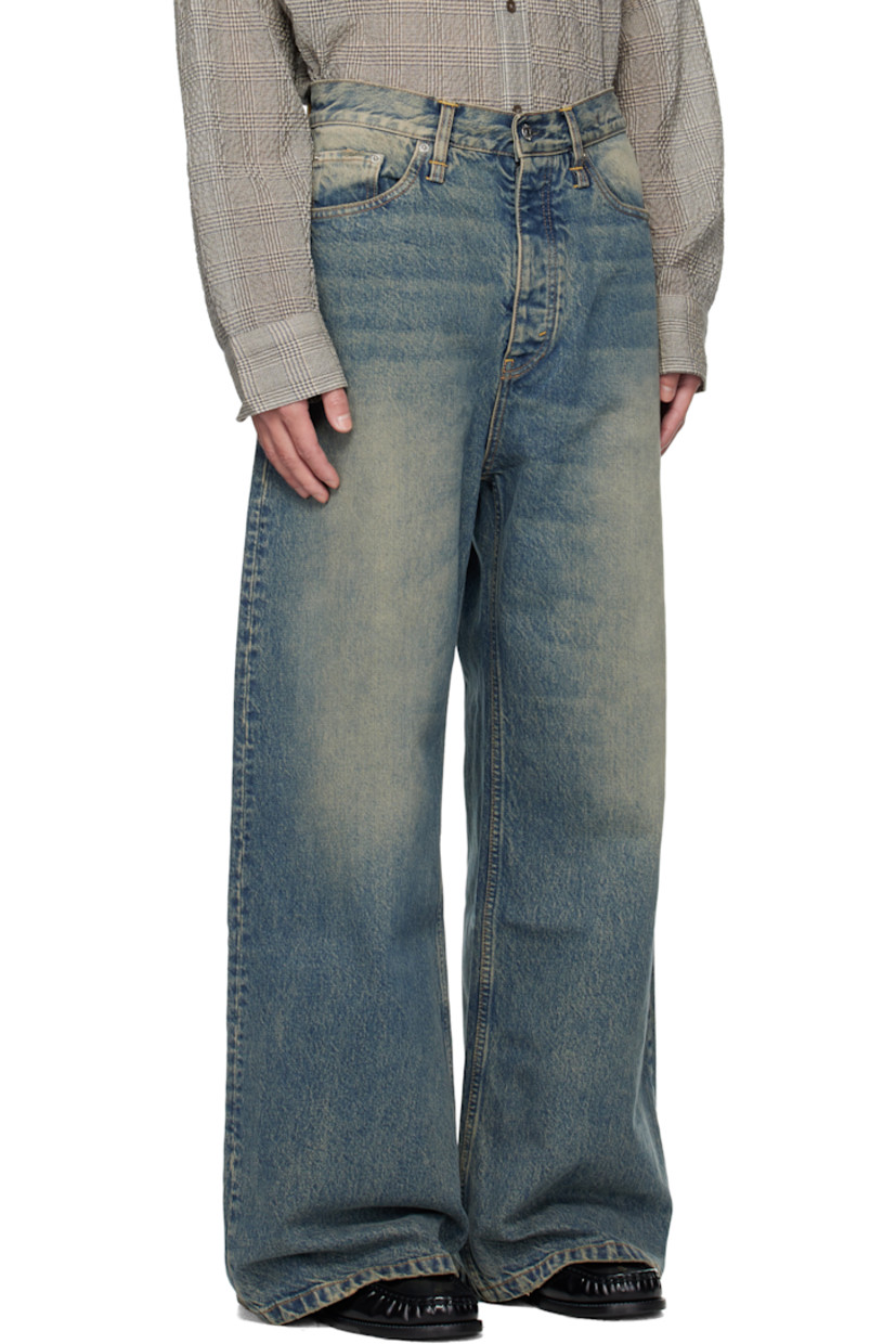 Non-stretch organic cotton denim jeans.

· Fading, whiskering, and hand-distressing throughout 
· Flared, wide-leg
· Belt loops
· Five-pocket styling
· Button fly 
· Dropped inseam
· Logo patch at back waistband
· Contrast stitching in tan 

Supplier color: Mid blue dirty
