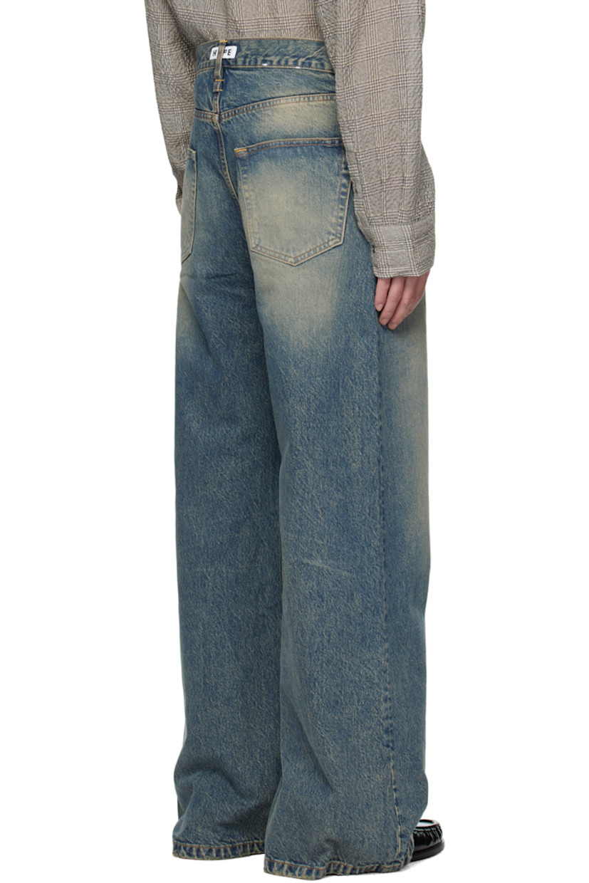 Non-stretch organic cotton denim jeans.

· Fading, whiskering, and hand-distressing throughout 
· Flared, wide-leg
· Belt loops
· Five-pocket styling
· Button fly 
· Dropped inseam
· Logo patch at back waistband
· Contrast stitching in tan 

Supplier color: Mid blue dirty