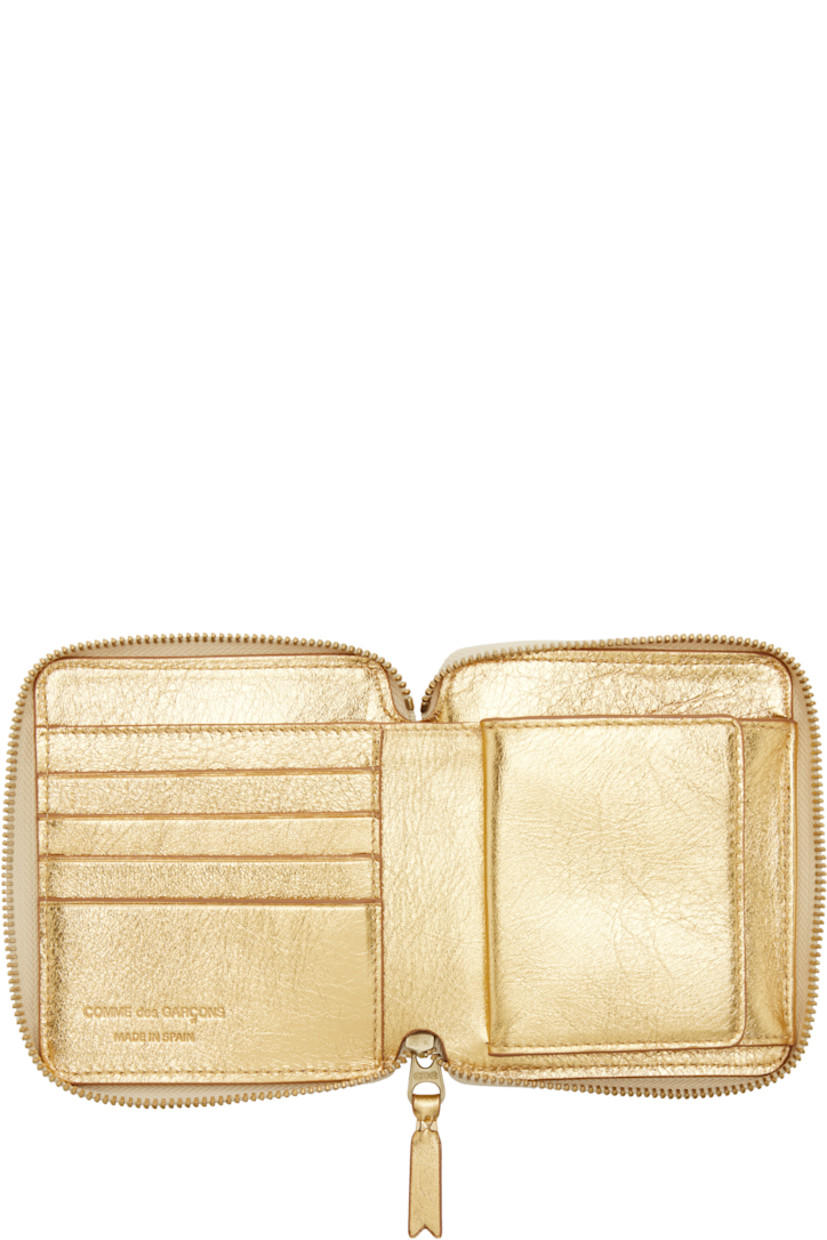Crinkled leather bifold wallet.

· Zip closure
· Four card slots
· Two patch pockets
· One note slot
· Flap coin compartment
· H4.25" x W4.75" x D1"

Supplier color: Gold
