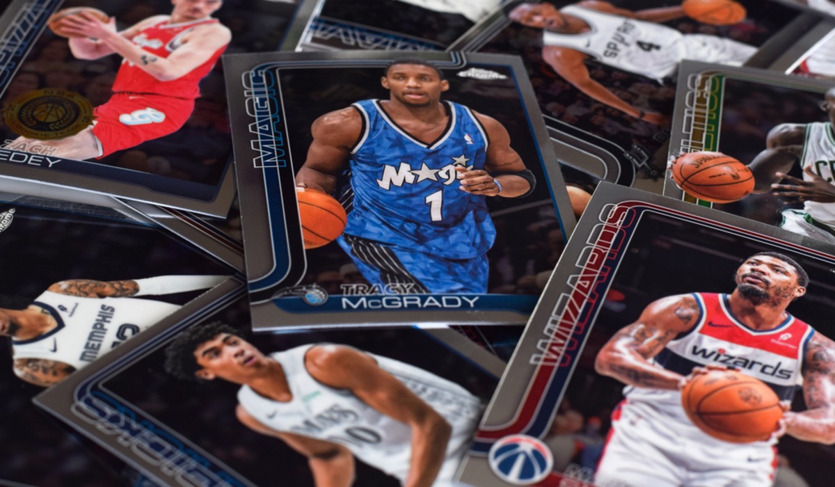 Trading cards spread across a white lattice table with a smartphone nearby
