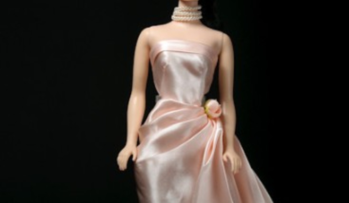 A woman poses elegantly in a silk dress